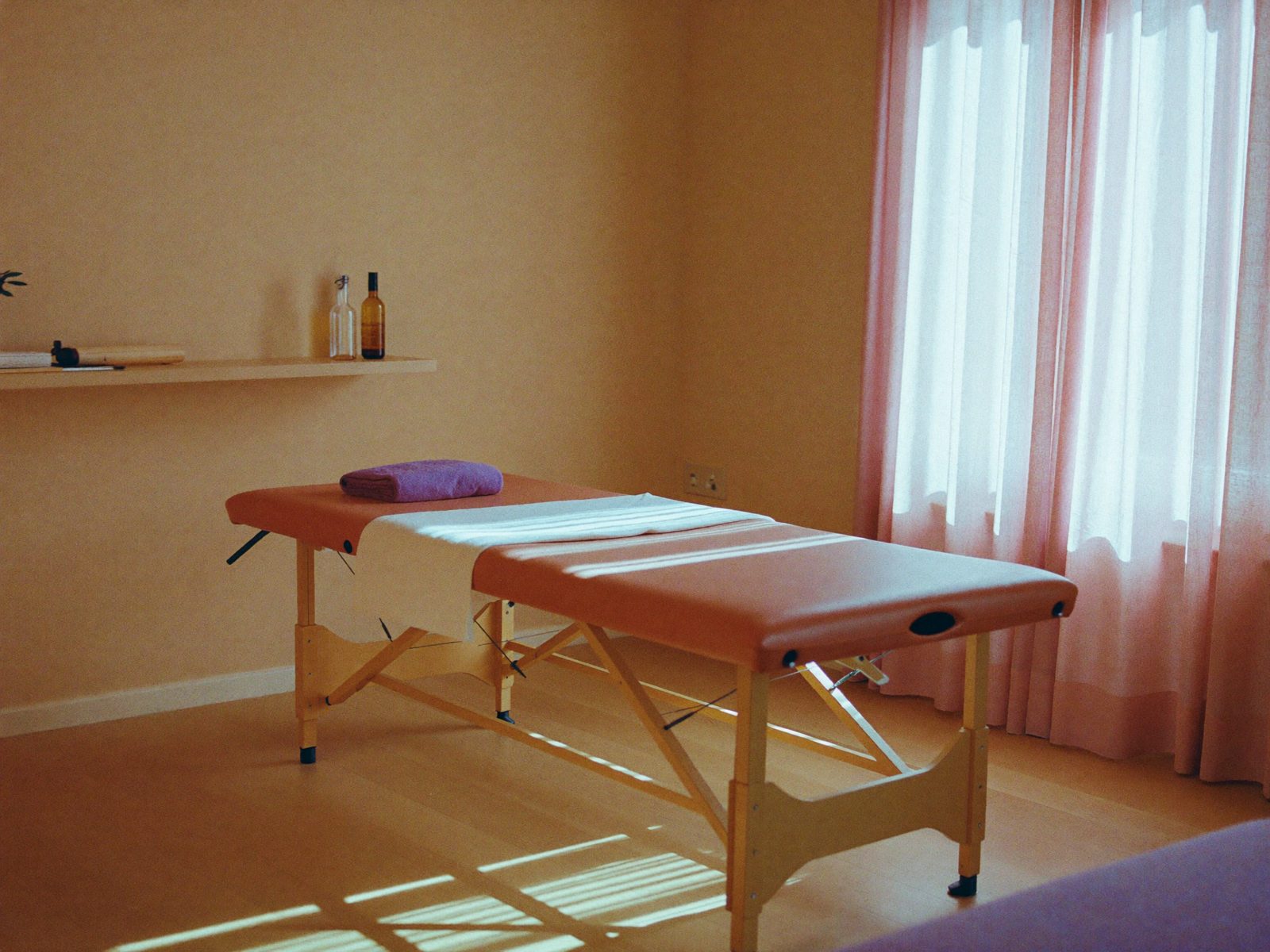 Sala de fisioterapia con camilla, luz natural y cortinas de lino